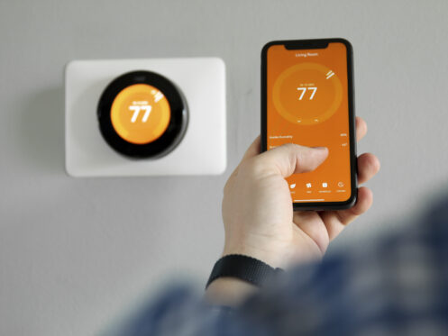 A man adjusting the smart thermostat from a phone.