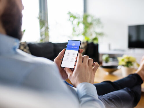 A man using his phone to set the thermostat in his home