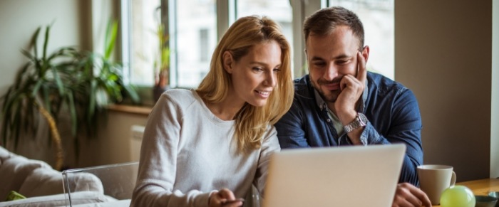 couple looking at rebates on their laptop